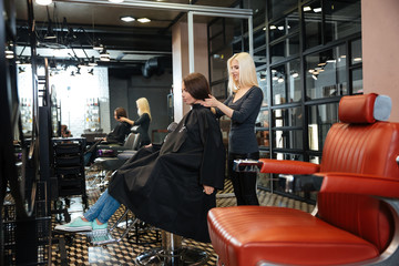 Young girl talking with hairdresser in beauty salon