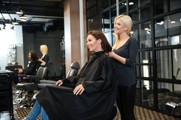Young girl talking with hairdresser in beauty salon