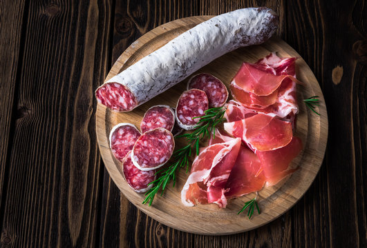 Spanish tapas with jamon and sausage on a wooden background