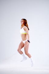 Young active woman with jump rope in studio