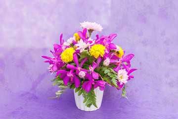 Bouquet of chrysanthemum and orchid flowers isolated on purple v