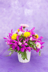 Bouquet of chrysanthemum and orchid flowers isolated on purple v