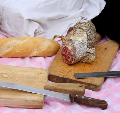 picinc with salami, fragrant bread and big knife and sandwiches