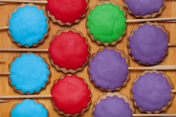 Gingerbread cookies with colored mastic on sticks on the old woo