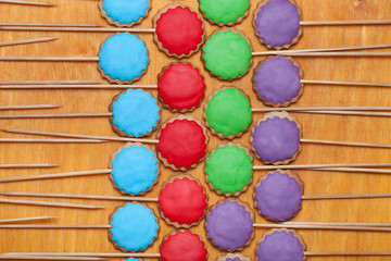 Gingerbread cookies with colored mastic on sticks on the old woo