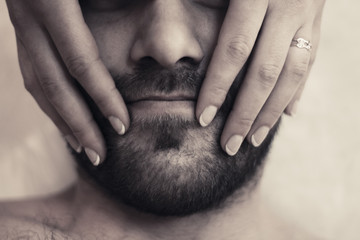 girl holding hands on the chin of a bearded man, manicure, love