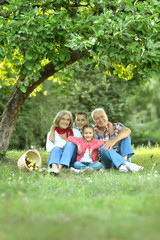 Obraz premium Family resting in park with apples