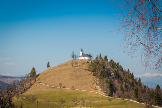 Ljubljana, Slovenia - March 19, 2016. The Sv. Jakob hill (806m) in the Polhov Gradec Hill Range with 16th century church of St. James on the top.