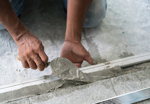 construction worker using trowel and mason's float
