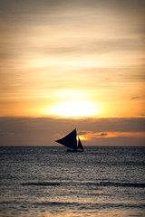 gold sunset with a sailboat