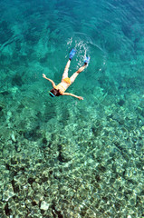 Young woman snorkeling in transparent shallow sea