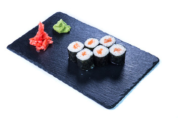 Sushi Set nigiri and sushi rolls on black stone slate. Restaurant food concept.