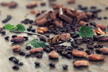Chocolate pieces with cocoa and coffee beans on a wooden table