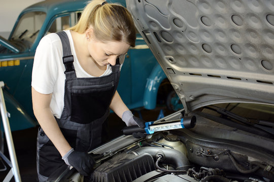 Kfz-Mechaniker bei Reparatur von Motor in Auto-Werkstatt 
