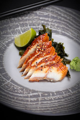 Japanese cuisine. Sushi. Eel  sashimi on a round plate
