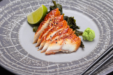Japanese cuisine. Sushi. Eel  sashimi on a round plate