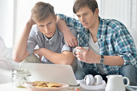 men watching video on laptop