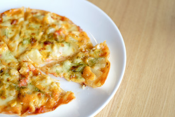 Hot pizza slice with melting cheese on wooden table