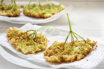 fried elderflower pancakes, traditional summer pastry on a white paper towel