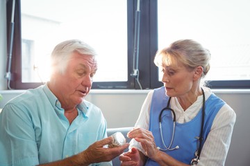 Nurse and senior man holding medicine
