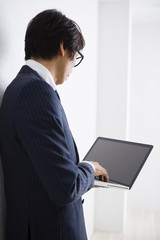 ノートパソコンを持つ男性