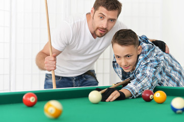 father and son playing billiards