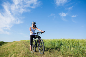 Fototapeta premium girl rides a bicycle in the countryside