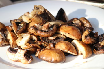 Grilled mushrooms on a white procelain plate