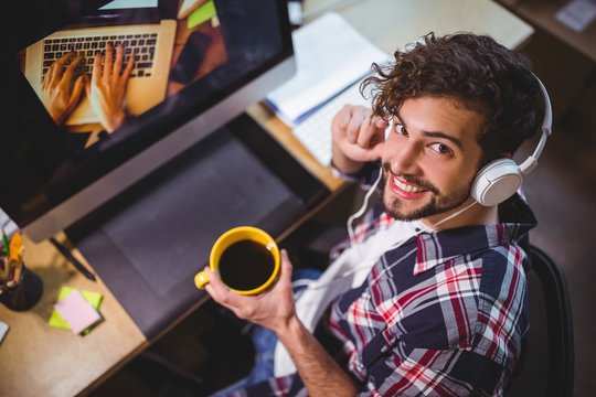 Portrait of happy creative businessman holding coffee cup - Powered by Adobe