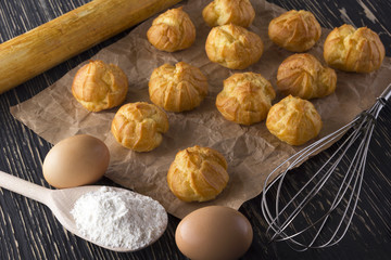 Tasty eclairs, eggs, flour and handle mixer.