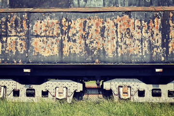 Vintage toned old rusty steam locomotive side, industrial background.