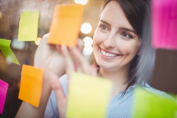 Creative businesswoman writing on sticky notes