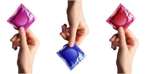 set of colored condom in female hand isolated on a white background