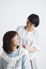 母親の肩をたたく娘