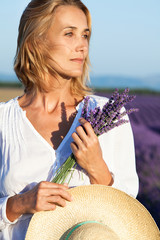 Fototapeta premium femme avec un bouquet de lavande dans les champs