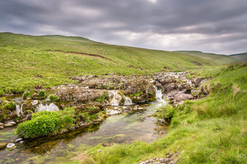 Fototapeta na wymiar Multiple falls in Coquetdale, as the River Coquet cascades from the Cheviot Hills through Northumberland