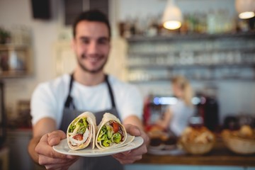 Waiter offering fresh rolls at cafe