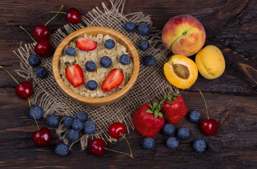 Breakfast with porridge, strawberry, blueberry and apricots