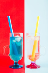 A couple of refreshing cocktails on red-blue background