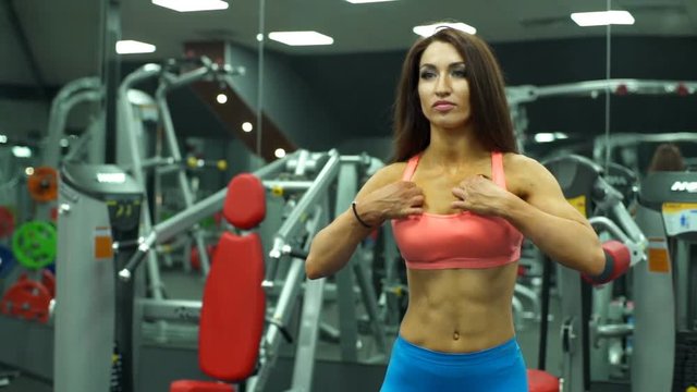sexy female bodybuilder during work out at the gym slow motion