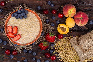 Breakfast with porridge, strawberry, cherry, blueberry and apric