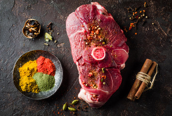 Raw Mutton meat with east spice on dark background.