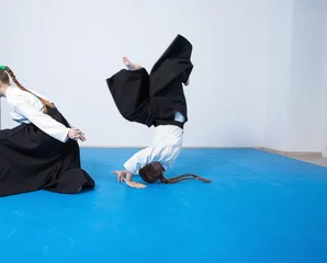 Papier Peint photo Arts martiaux Two girls in black hakama practice Aikido on martial arts training. Safe falling