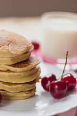 Tasty Pancake with fresh cherries on a white plate. American breakfast