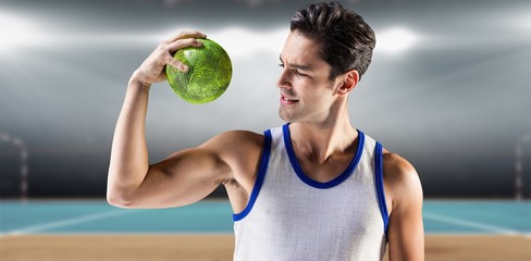 Composite image of happy male athlete holding a ball