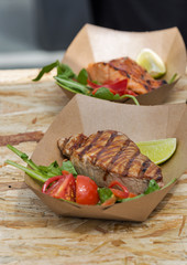 street food tuna and salmon steaks served with vegetables closeup