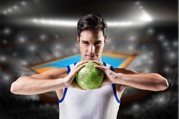 Composite image of portrait of happy athlete man holding ball 
