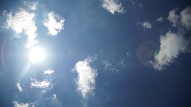 Time-lapse film of hot sun background with clouds and flare