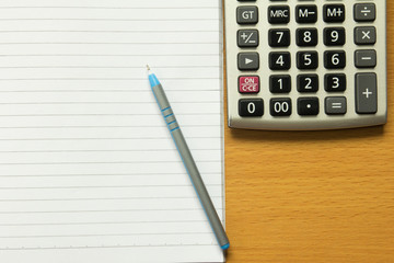 Paper note with blue pen, calculator