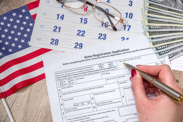 Woman filling President Registration Application, flag and money